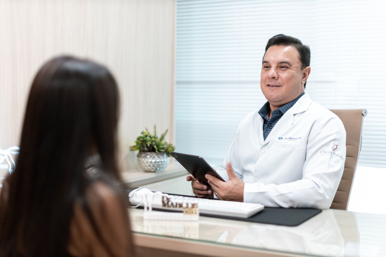 Dr. Marcos Dib conversando com uma paciente durante a consulta