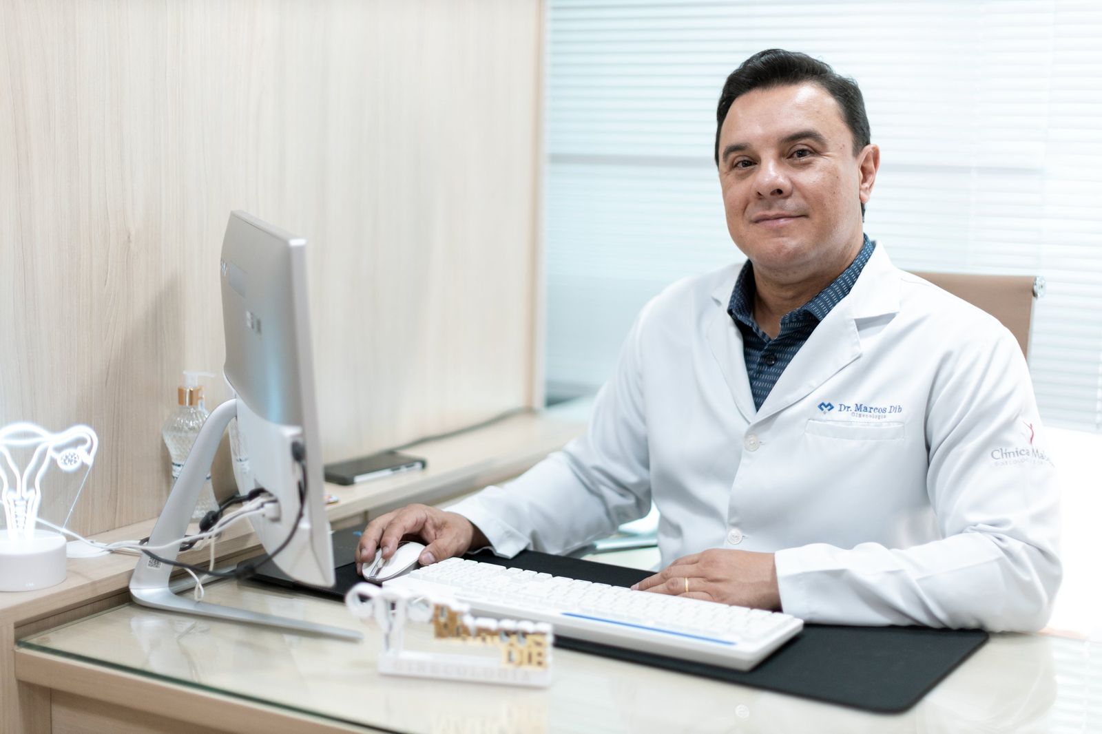 Dr. Marcos Dib em sua mesa no consultório